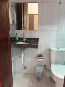 a bathroom with a toilet and a sink and a mirror at Casa dos Ventos Barreirinhas in Barreirinhas