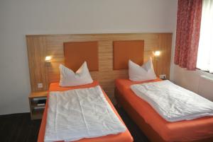 two beds in a hotel room with two bedsvisor at Hotel Art-Ambiente in Hagen