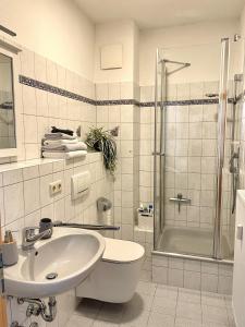 a white bathroom with a sink and a shower at Fewo Seehaase in Radolfzell am Bodensee