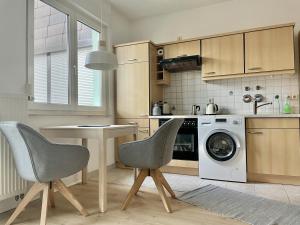 a kitchen with two chairs and a washing machine at Fewo Seehaase in Radolfzell am Bodensee +6 photos