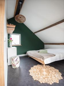 1 dormitorio con cama y pared verde en La Casa Gardenia en Drunen