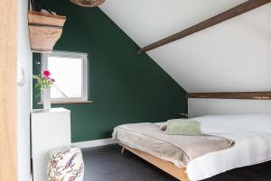 Dormitorio verde con cama y ventana en La Casa Gardenia, en Drunen