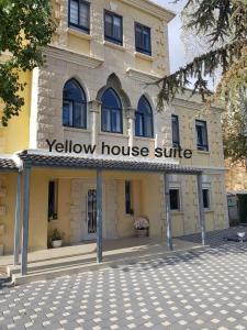 Una casa amarilla con un cartel en la parte delantera. en Yellow House Suite, en Majdal Shams