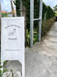 un cartel que dice mostrar vida en el hostal de la playa en Slowlife Beach, en Nai Yang Beach