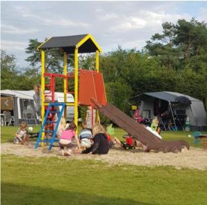 eine Gruppe von Kindern, die auf einem Spielplatz spielen in der Unterkunft Chalet Olm 22 in Zoerte