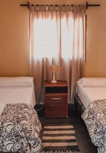 um quarto com 2 camas e uma janela em EL PEDREGAL Casa en Cafayate em Cafayate