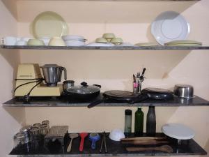 un estante de cocina con platos y utensilios. en AMBIENT HOME STAY, In Nashik, en Nashik