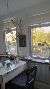 a table with a chair in a kitchen with a window at B en B Sluisje 1818 in Utrecht