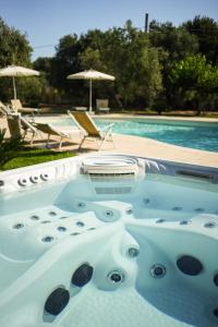 a hot tub in front of a swimming pool at Villa de Lua in Leporano