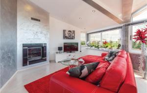 czerwona kanapa w salonie z kominkiem w obiekcie Nice Home In Galizana w mieście Galižana