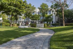 a walkway through a park in front of a building at STAY BY LATINEM Luxury 2BR Holiday Home CV B1309 Near Burj Khalifa in Dubai