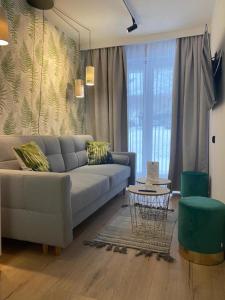 a living room with a couch and a table at Apartamenty Admirał  in Solina
