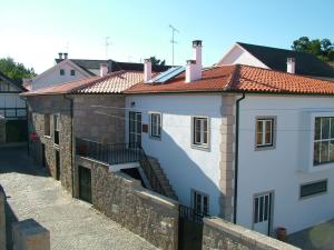 a white building with a staircase next to a wall at Casa d Toninha - Casas de Campo - Turismo Espaço Rural - AL in Sernancelhe