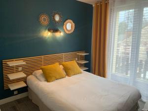 - une chambre avec un lit doté d'oreillers jaunes et d'une fenêtre dans l'établissement Auberge Du Cheval Blanc, à Crèvecoeur-en-Auge