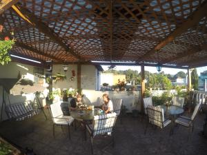 zwei Personen, die an einem Tisch unter einer Pergola sitzen in der Unterkunft Mariana's Petit Hotel in Guatemala