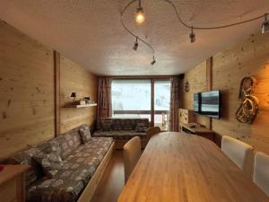 ein Wohnzimmer mit einem Tisch und einem Sofa in der Unterkunft Appartement Les Menuires, 2 pièces, 4 personnes - FR-1-452-177 in Les Menuires