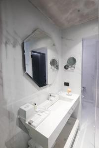 a white bathroom with two sinks and a mirror at Maritim Marina Bay Resort & Casino Adult Friendly in Vlorë