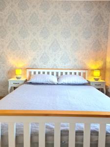 a bedroom with a white bed with two lamps on tables at Old Town Apartment in Telšiai