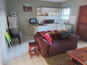 ein Wohnzimmer mit einem Sofa und einer Küche in der Unterkunft Elegant 1-Bedroom Apartment with pool. in Richards Bay