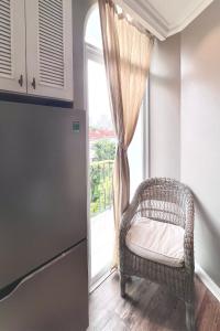 胡志明市的住宿－HOME by FLATTO APARTMENT，厨房在窗户前配有藤椅