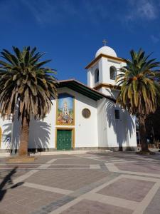 una iglesia con dos palmeras delante en Departamento Carrodilla Luján, en Ciudad Lujan de Cuyo