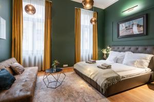 布達佩斯的住宿－Luxory place in the heart of Budapest，一间卧室设有绿色的墙壁、一张床和一张沙发