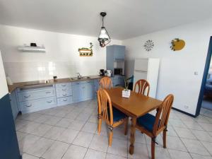 kuchnia ze stołem, krzesłami i lodówką w obiekcie Maison individuelle 60 m² w mieście Le Cateau +3 zdjęcia