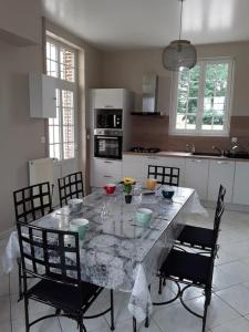 una cocina con una gran mesa de mármol con sillas en Chez DOUDOU entre terre et mer, en Bretteville-Saint-Laurent