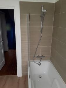 a bathroom with a bath tub with a shower at Chez DOUDOU entre terre et mer in Bretteville-Saint-Laurent +9 photos