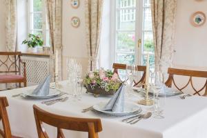 una mesa con un mantel blanco con dos botes. en Landhaus Plendl, en Oberappersdorf