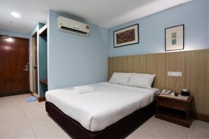 sypialnia z dużym łóżkiem i telefonem w obiekcie Orkid Hills Hotel w Kuala Lumpur