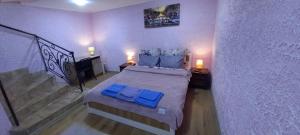Un dormitorio con una cama con almohadas azules y una escalera en Двухярусная квартира в центре Мукачева, улица Мира, en Mukácheve