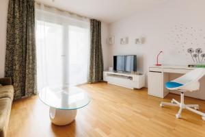 uma sala de estar com uma mesa de vidro e uma televisão em Home in Vienna by Oberlaa Therme - 15 min to the city center em Viena