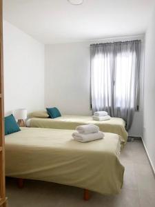 a room with three beds with towels on them at Casa Alejandro 5 Las Vistas in Los Cristianos