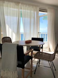 einen Tisch und Stühle in einem Zimmer mit Fenster in der Unterkunft Casa Alejandro 5 Las Vistas in Los Cristianos