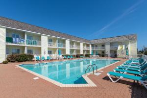 einen Pool in einem Hotel mit Liegestühlen und einem Resort in der Unterkunft Villas of Hatteras Landing by KEES Vacations in Hatteras