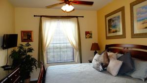 a bedroom with a bed with a ceiling fan and a window at Windsor Hills Resort- 405 in Orlando