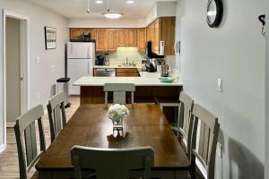 a kitchen with a wooden table with chairs and a refrigerator at Cozy Condo with Mtn Views, Pool, Hot Tub, and Balcony! in Lincoln