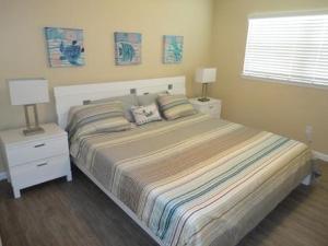 1 dormitorio con 1 cama con 2 mesitas de noche y 2 lámparas en Richard Arms Unit 15, en Cocoa Beach