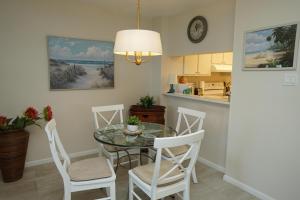 a kitchen and dining room with a table and chairs at Canaveral Towers Oceanfront 402! in Cape Canaveral