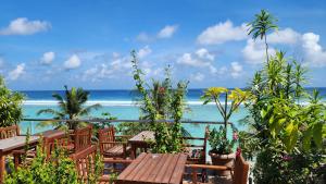 a table and chairs with the ocean in the background at Hathaa Beach Maldives in Hulhumale