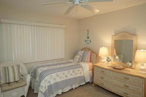 a bedroom with a bed and a mirror and a chair at Canaveral Towers Oceanfront 402! in Cape Canaveral +27 photos