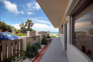 a house with a sidewalk next to a fence and a car at Quiet Vista Del Mar 2 Bedroom Condo Beachfront Property in Cocoa Beach