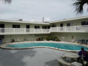 a large pool in front of a hotel at Quiet Vista Del Mar 2 Bedroom Condo Beachfront Property in Cocoa Beach