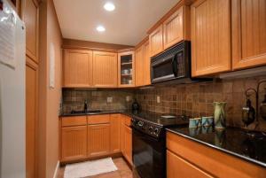 a kitchen with wooden cabinets and a stove top oven at Quiet Vista Del Mar 2 Bedroom Condo Beachfront Property in Cocoa Beach
