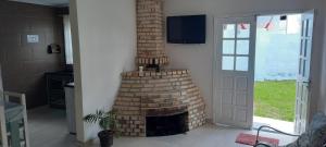 a brick fireplace in a living room next to a door at POUSADA BLUE GARDEN in Lages