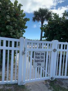 uma cerca branca com um sinal. em Richard Arms Unit 12 em Cocoa Beach