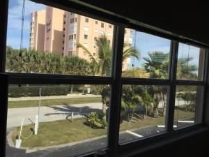 可可比奇的住宿－Richard Arms Unit 12，从棕榈树建筑的窗户欣赏美景