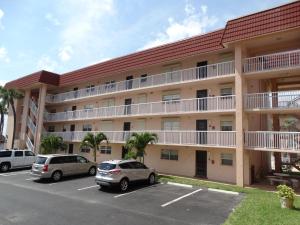 an apartment building with cars parked in a parking lot at Spanish Main Unit 4- Direct Oceanfront Condo! in Cocoa Beach