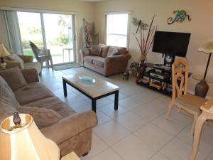 a living room with a couch and a tv at Spanish Main Unit 4- Direct Oceanfront Condo! in Cocoa Beach